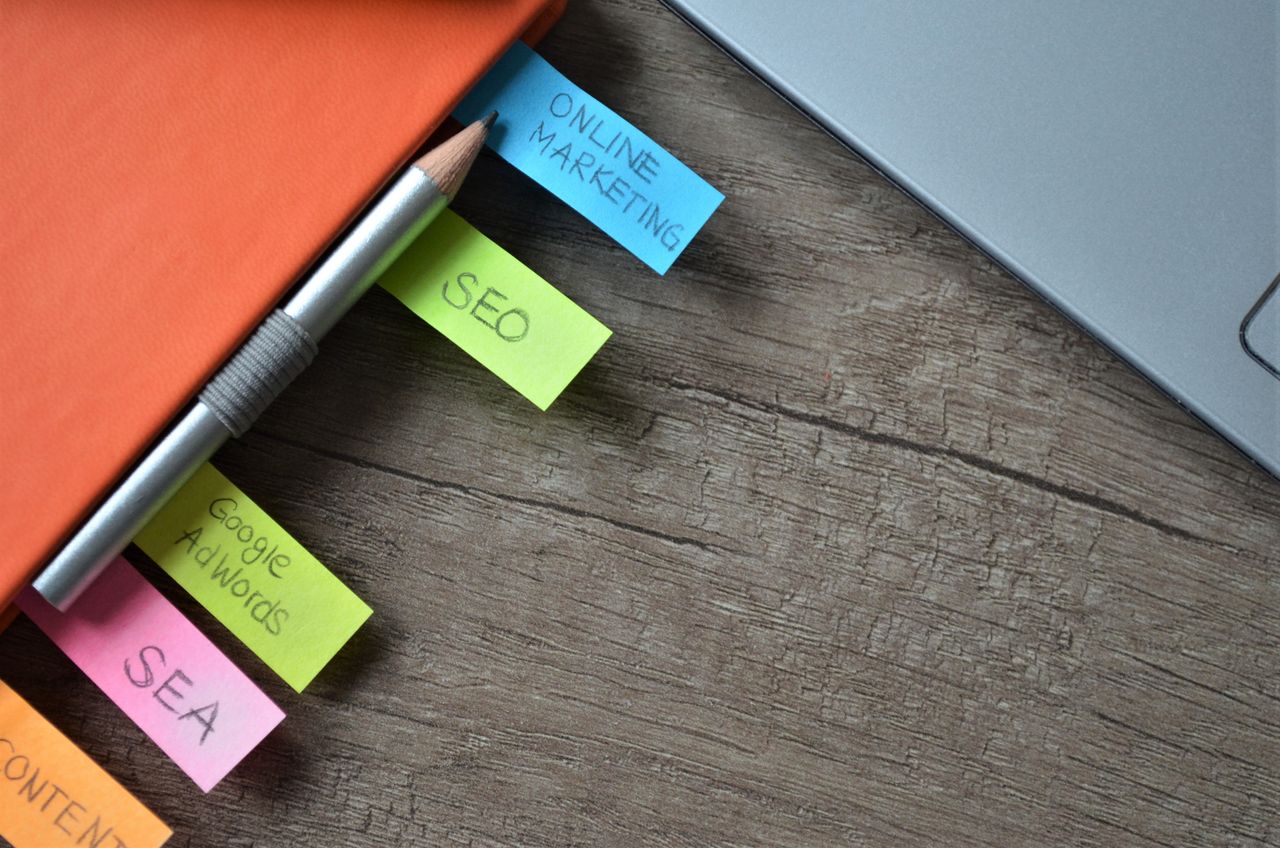 services-03 Close-up of SEO strategy planner with colorful sticky notes and a pencil on a notebook.